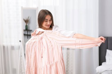 İçeriden giyinen çekici bir kadın. Kıyafet seçiyorum.