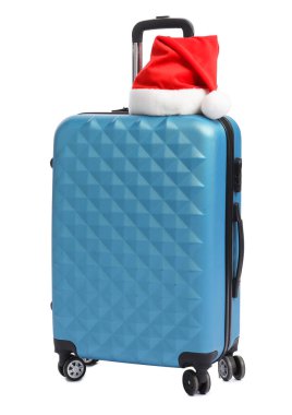 Beyaz arka planda mavi bavullu Noel Baba şapkası. Noel tatili