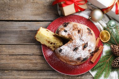 Lezzetli noel panettone pastası pudra şekeri ve ahşap masa üzerinde şenlikli dekorasyon, düz yatış. Metin için boşluk