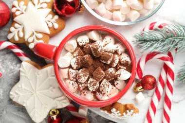 Lezzetli kakao, lokum, baston şekerler, zencefilli kurabiye ve Noel dekoru gri masada, düz uzanmış