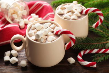 Marşmelovlu lezzetli kakao, baston şekerler ve ahşap masada Noel dekoru, yakın plan.