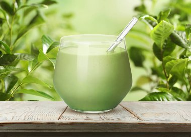 Kibrit yeşil yapraklara karşı ahşap masada camdan içilir.