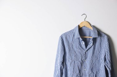 Işık duvarının yanında kareli gömlekli bir askı. Metin için boşluk