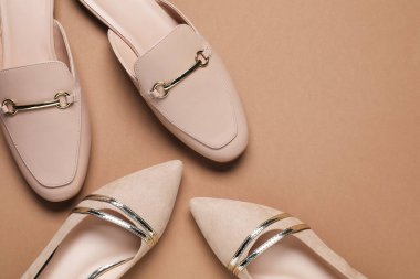 Bej arka planda farklı şık ayakkabılar, düz yatış. Metin için boşluk