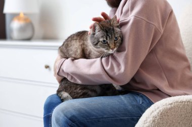 Evinde sevimli kedisi olan bir adam, yakın plan.