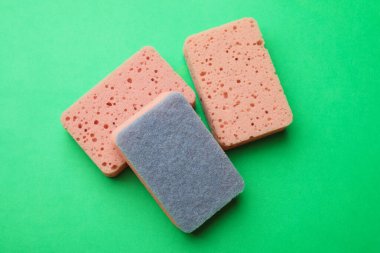 Mutfak süngerleri yeşil arka planda, düz yerde