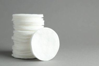 Açık gri arka planda temiz pamuk pedleri, yakın plan. Metin için boşluk