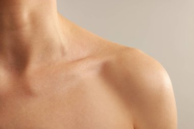 Açık gri arka planda normal ciltli kadın, yakın plan.