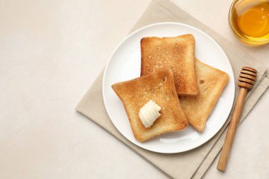 Tost ekmeği, tereyağı ve bal dilimleri bej masa, düz yatak. Metin için boşluk