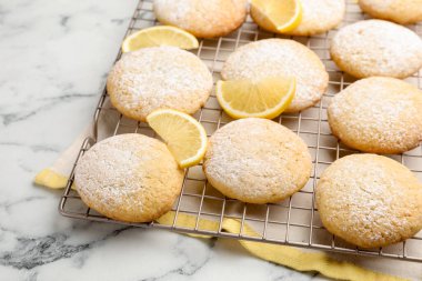 Lezzetli limonlu kurabiyeler ve beyaz mermer masada meyve dilimleri, yakın plan.