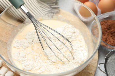 Gri masa üzerinde hamur ve çırpmak için farklı malzemeler.