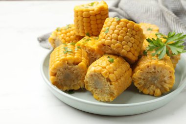 Beyaz masada maydanozlu mısır koçanları, yakın plan.