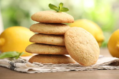 Lezzetli limonlu kurabiyeler, nane ve meyveler ahşap masada bulanık arka plan, yakın plan