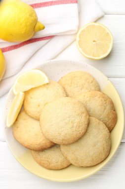 Lezzetli limonlu kurabiyeler ve beyaz ahşap masada meyveler.