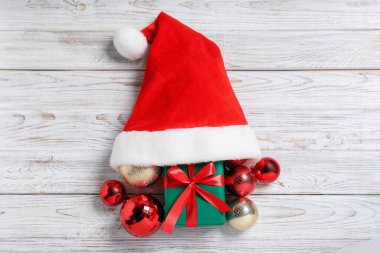 Noel Baba şapkası, Noel hediyesi ve takılar açık ahşap masa, düz uzanma