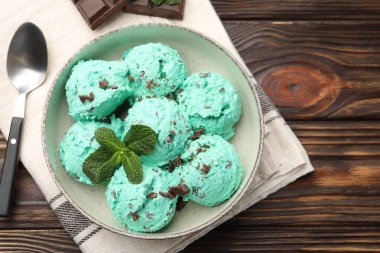 Tahta masa üzerinde sunulan yapraklı naneli çikolata parçalı dondurma.