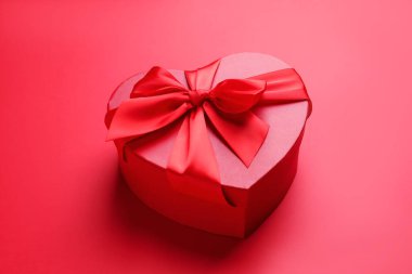 Sevgililer Günün kutlu olsun. Kırmızı arkaplanda kalp şeklinde hediye kutusu, yakın plan.