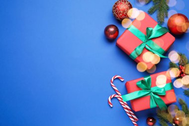 Paketlenmiş Noel hediyeleri ve mavi arka planda dekorasyon, düz yatış. Metin için boşluk