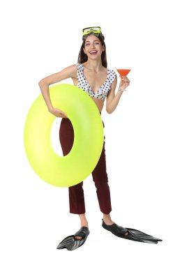 Kokteyl, dalış maskesi, paletleri ve beyaz arka planda şişme yüzüğü olan bir iş kadını.