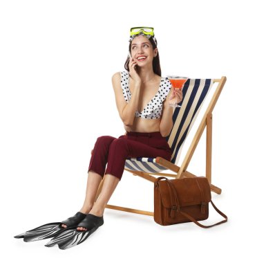 Dalgıç maskeli, kokteyl ve palet giyen iş kadını güverte sandalyesinde beyaz arka planda akıllı telefondan konuşuyor.
