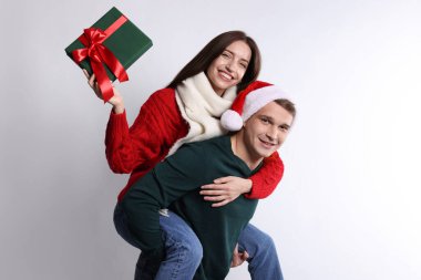 Mutlu çift Noel hediyesiyle aydınlık arka planda