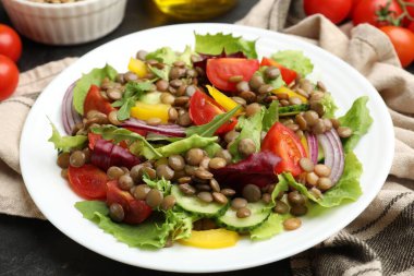 Gri masada mercimek ve sebzeli lezzetli salata, yakın plan.