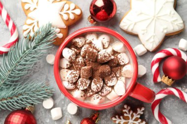 Lezzetli kakao, lokum, baston şekerler, zencefilli kurabiye ve Noel dekoru gri masada, düz uzanmış