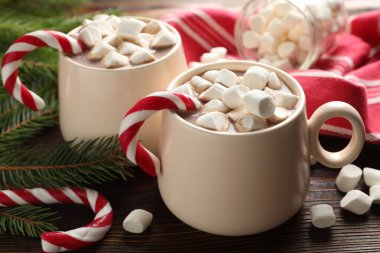 Marşmelovlu lezzetli kakao, baston şekerler ve ahşap masada Noel dekoru, yakın plan.