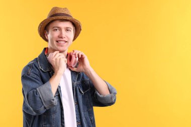 Sarı arka planda kulaklıklı adam. Metin için boşluk