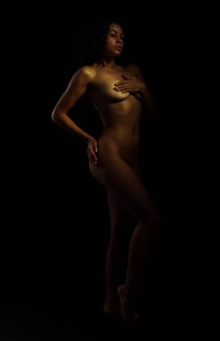 Siyah arka planda poz veren güzel çıplak kadın.