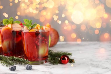 Noel için Sangria içkisi. Bokeh ışıklarına karşı masada gözlüklü ve dekorlu lezzetli bir içecek. Metin için boşluk