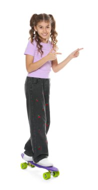 Gülümseyen kız beyaz arka plandaki bir şeyi işaret ediyor.