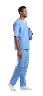 Beyaz arka planda panosu olan, tıbbi üniformalı gülümseyen bir doktor.