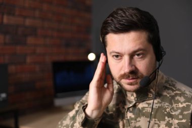 Askerlik. Ofiste çalışan kulaklıklı asker, metin için alan