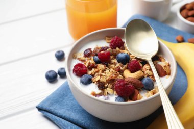 Sağlıklı kahvaltı. Fındıklı yulaf ezmesi, böğürtlen ve süt beyaz ahşap masada, yakın plan. Metin için boşluk
