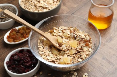 Tahıl yapıyorum. Tahta masada kurumuş meyveli yulaf gevrekleri, yakın plan.