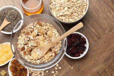 Tahıl yapıyorum. Yulaf gevreği, kurutulmuş meyve, chia tohumu ve bal ile ahşap masa üzerinde yassı kompozisyon.