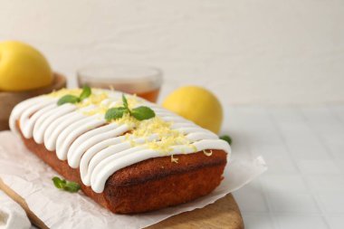 Beyaz fayanslı masada servis edilen krema, tat ve nane ile süslenmiş lezzetli limonlu pasta, yakın plan. Metin için boşluk