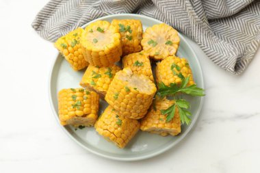 Beyaz masada maydanozlu mısır koçanı parçaları.