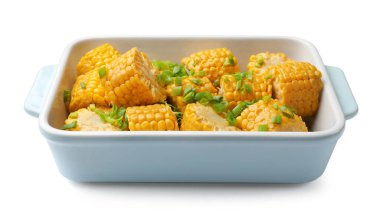 Pişirme kabında yeşil soğanlı haşlanmış mısır koçanı parçaları beyaza izole edilmiş.