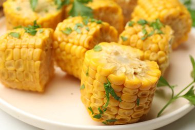 Masada maydanozlu haşlanmış mısır koçanı parçaları, yakın plan.