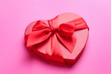 Sevgililer Günün kutlu olsun. Pembe arka planda kalp şeklinde hediye kutusu, yakın plan.