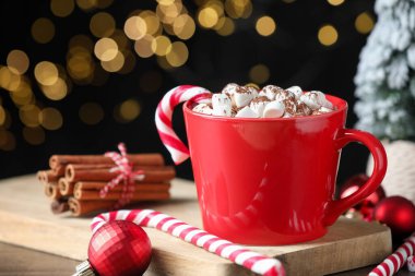 Lokum, şeker kamışı, tarçın ve Noel dekorlu lezzetli kakao siyah arka planda bulanık ışıklarla, yakın plan. Bokeh etkisi