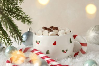 Marşmelovlu lezzetli kakao, baston şekerler ve yapay kar üzerine Noel dekoru, yakın plan.