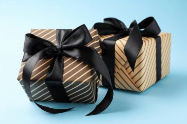 Açık mavi arkaplanda güzel paketlenmiş hediyeler, yakın plan.