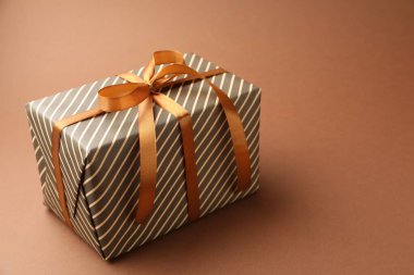 Kahverengi arka planda güzel bir hediye, yakın plan. Metin için boşluk