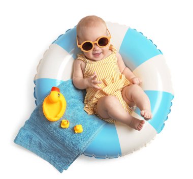 Güneş gözlüklü mutlu küçük bebek, oyuncak ördekler ve havluyla beyaz arka planda şişme halka, üst manzara