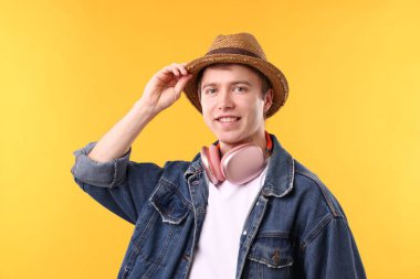 Sarı arka planda kablosuz kulaklıklı adam.