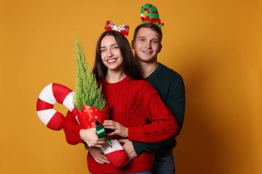 Yılbaşı bantlı, sarı arka planda şeker kamışı olan mutlu çift.