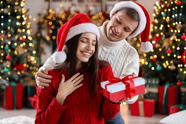 Mutlu erkek arkadaşı evde Noel hediyesiyle kız arkadaşına sürpriz yapıyor.